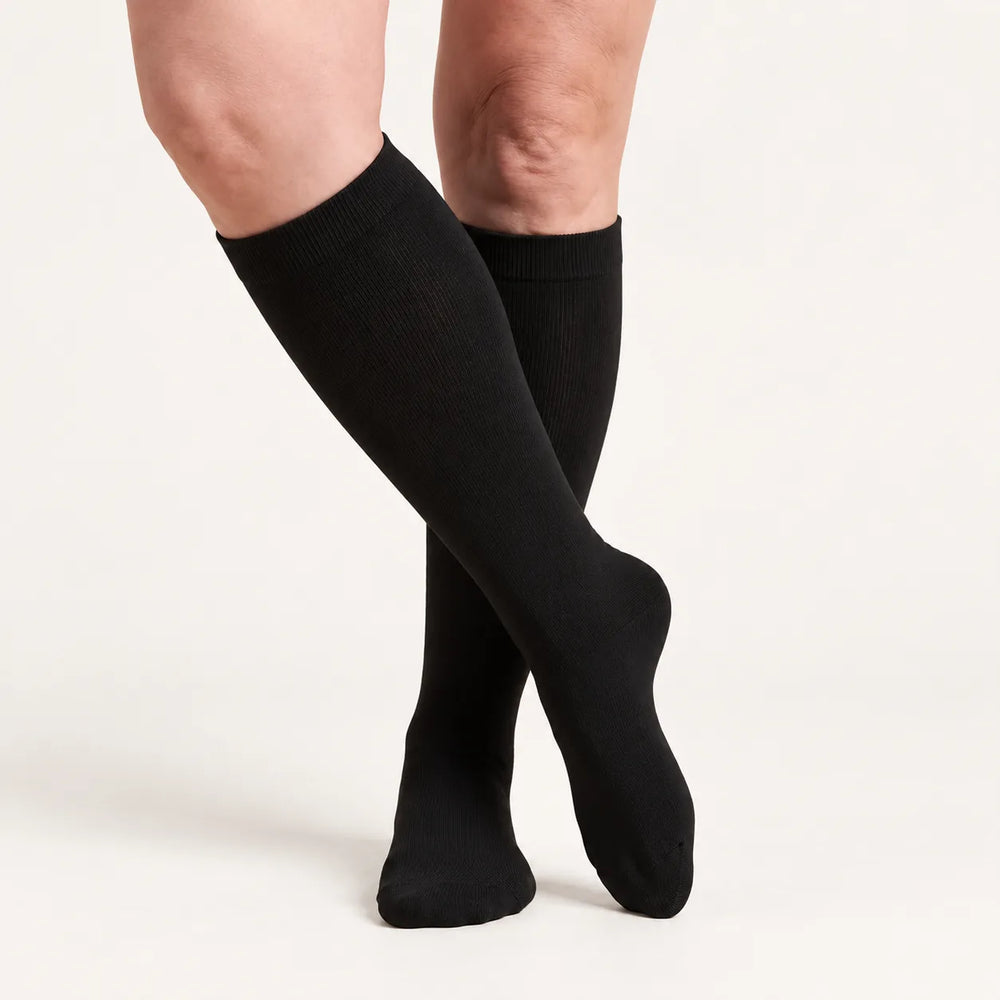 Calze a compressione Lovelle Lift, colore Nero – al ginocchio, gambe accavallate
