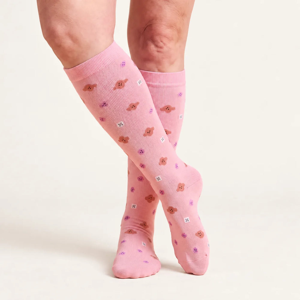 Calze a compressione Lovelle Lift, colore Fiorellini rosa – al ginocchio, gambe accavallate
