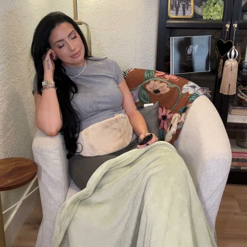 Donna che riposa in poltrona con Lovelle Hug sulla pancia